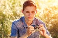 A young man with a camera taking pictures of the natural background sun rays tinted Royalty Free Stock Photo