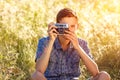 A young man with a camera taking pictures of the natural background sun rays tinted