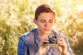 A young man with a camera taking pictures of the natural background sun rays tinted Royalty Free Stock Photo