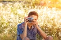 A young man with a camera taking pictures of the natural background sun rays tinted Royalty Free Stock Photo