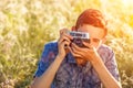 A young man with a camera taking pictures of the natural background sun rays tinted Royalty Free Stock Photo