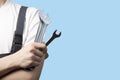 A young man in a car service worker's overalls on a white background.An employee of physical labor