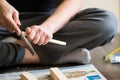 Young man, carpenter, handyman working with wood - polishing piece of wood with special devices