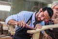Young man carpenter working make furniture, Male carpenter happy to work in wood factory and is doing polishing job to make wood Royalty Free Stock Photo