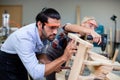 Young man carpenter working make furniture, Male carpenter happy to work in wood factory and is doing polishing job to make wood Royalty Free Stock Photo