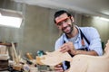 Young man carpenter working make furniture, Male carpenter happy to work in wood factory and is doing polishing job to make wood Royalty Free Stock Photo