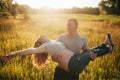 A young man carries on arms his pregnant wife during the walk