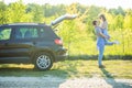 Young pretty man carrying a woman on his back near car while on a road trip Royalty Free Stock Photo