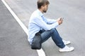 Young man in casual clothes and modern leather bag sitting on th Royalty Free Stock Photo