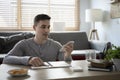 Man in casual clothes sitting on the floor in living room and talking on smart phone. Working weekend concept. Royalty Free Stock Photo