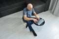 Young man in casual clothes sitting on floor and working on his laptop computer at home. Stay home and work online. Quarantine Royalty Free Stock Photo