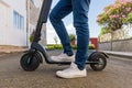 Young man in casual clothes standing on an electric scooter Royalty Free Stock Photo