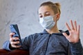 Young man in casual conversation over video call on cellphone in protective mask due to spread of coronavirus epidemic