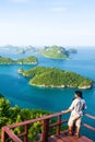 Young man on viewpoint at the top of Koh Wua Ta Lap while enjoying scenery of blue sea with lots of islands