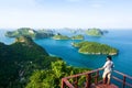 Young man on viewpoint at the top of Koh Wua Ta Lap while enjoying scenery of blue sea with lots of islands