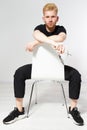 Young man on a chair, Portrait of handsome young man sitting on a chair, Proud and satisfied young man sitting on chair