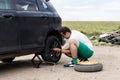 Young man changing the punctured tyre