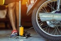 Young man check inflator pressure and inflates tire on motorcycle with bicycle floor pump. People checking air pressure and Royalty Free Stock Photo
