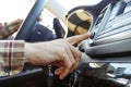 Car interior with male driver sitting behind the wheel, soft sunset light. Luxurious vehicle dashboard and electronics. Royalty Free Stock Photo