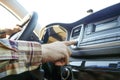 Car interior with male driver sitting behind the wheel, soft sunset light. Luxurious vehicle dashboard and electronics. Royalty Free Stock Photo