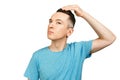 Young man checking hair in mirror, dressed in a blue t shirt, isolated Royalty Free Stock Photo