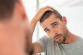 Young man checking hair in mirror Royalty Free Stock Photo