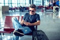 Young man checking his phone while waiting his flight in the air Royalty Free Stock Photo