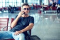 Young man checking his phone while waiting his flight in the air Royalty Free Stock Photo