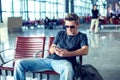 Young man checking his phone while waiting his flight in the air Royalty Free Stock Photo