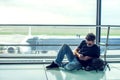 Young man checking his phone while waiting his flight in the air Royalty Free Stock Photo