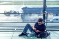 Young man checking his phone while waiting his flight in the air Royalty Free Stock Photo