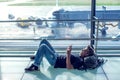 Young man checking his phone while waiting his flight in the air Royalty Free Stock Photo