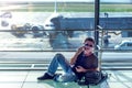 Young man checking his phone while waiting his flight in the air Royalty Free Stock Photo