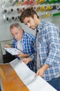 Young man checking printing quality industrial printer Royalty Free Stock Photo