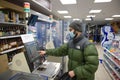 Young man checks out at a self service till in Tesco with face covered Royalty Free Stock Photo