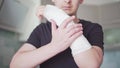 A young man checks the plaster bandage for strength by touching a broken arm close-up