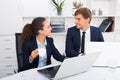 young man and cheerful woman coworkers talking in firm office Royalty Free Stock Photo