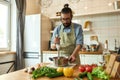 Young man, chef cook using hand blender while preparing Italian meal in the kitchen Royalty Free Stock Photo