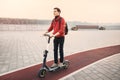 Young man chooses not public transport, but a personal or rented electric scooter to get to work quickly and safely