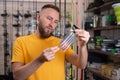 Young man choosing fishing accessories in the sports shop. Tackle and silicone bait for fishman. Royalty Free Stock Photo