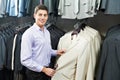 Young man choosing suit in clothes store Royalty Free Stock Photo