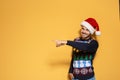 Young man in Christmas sweater and hat on color background. Royalty Free Stock Photo