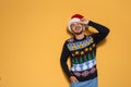 Young man in Christmas sweater and hat on color background Royalty Free Stock Photo