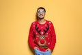 Young man in Christmas sweater with party glasses