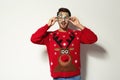 Young man in Christmas sweater with party glasses