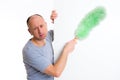 Young man cleaning with feather duster Royalty Free Stock Photo