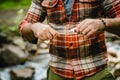 Young man cleaning his teeth while resting by river in forest Royalty Free Stock Photo