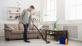 Young man cleaning house with vacuum cleaner Royalty Free Stock Photo