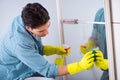 The young man cleaning mirror at home hotel Royalty Free Stock Photo