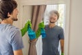 Young man cleaning mirror at home hotel